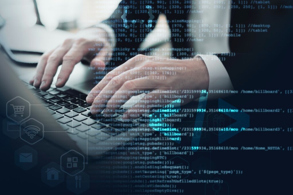 Persona trabajando en una laptop con código y símbolos de ciberseguridad